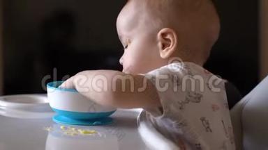 小可爱的男孩开心地用手吃着婴儿粥，真诚地微笑着